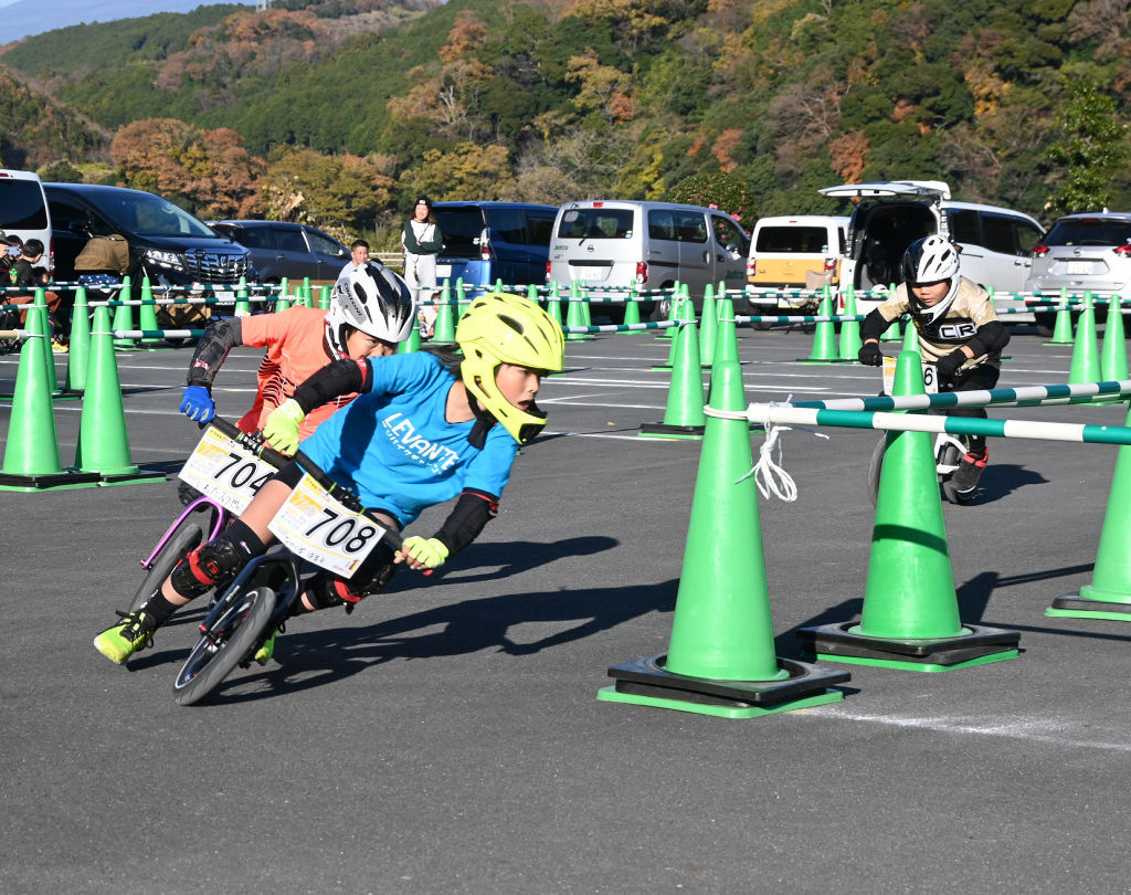 レースを繰り広げる子どもたち＝富士市の富士川体育館駐車場