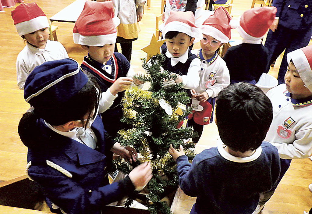 反射材でクリスマスツリーを彩る園児たち＝御殿場市の竈幼稚園