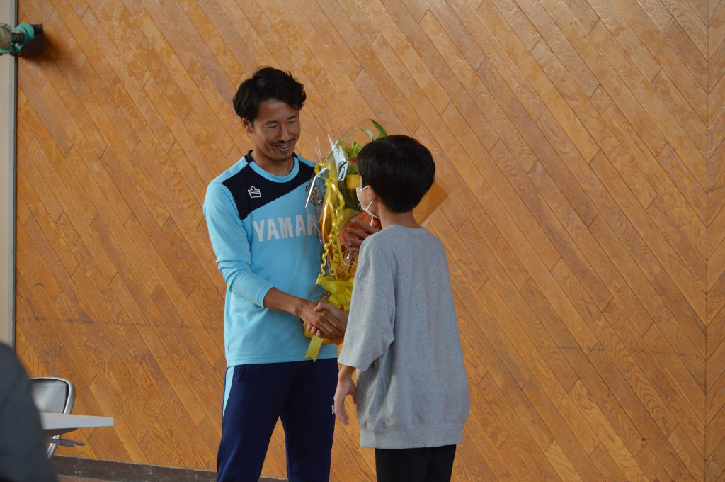 児童から花束を受け取る山田選手（左）＝浜松市南区の芳川北小