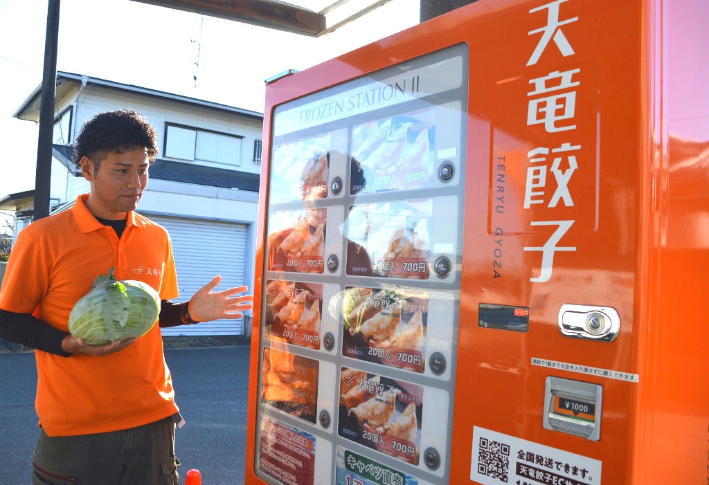 冷凍生餃子を扱う自動販売機を紹介する上村さん＝磐田市長森