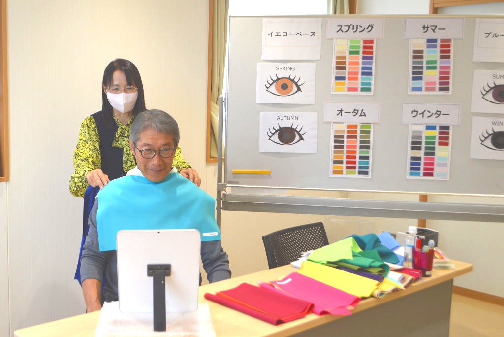 水色の布を付けて顔の印象を確認する参加者＝１６日、長泉町のパルながいずみ