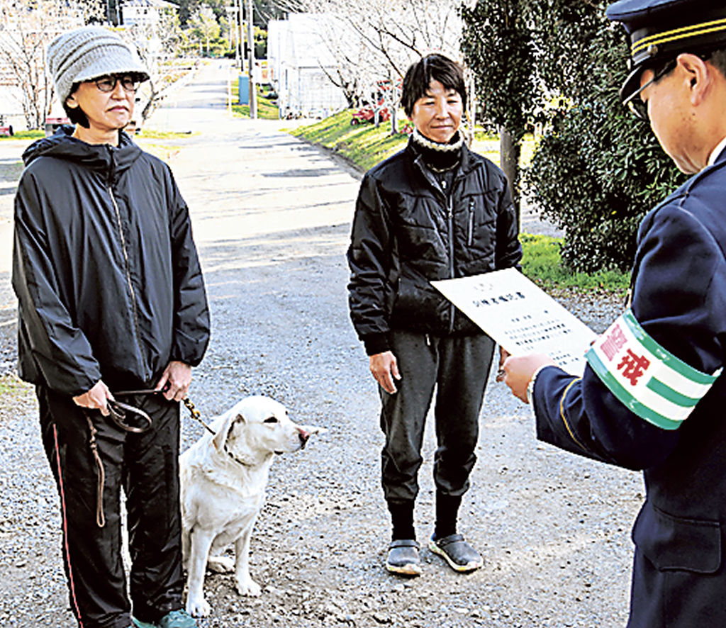 竹下署長（右）から嘱託書を受け取る警察犬の飼い主と訓練者＝菊川市内