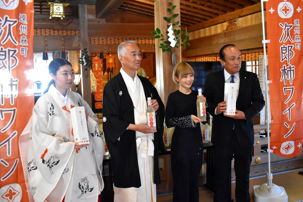 「遠州森町次郎柿ワイン」の完成を祝う鈴木会長（右）、東田さん（右から２人目）ら＝森町の小国神社