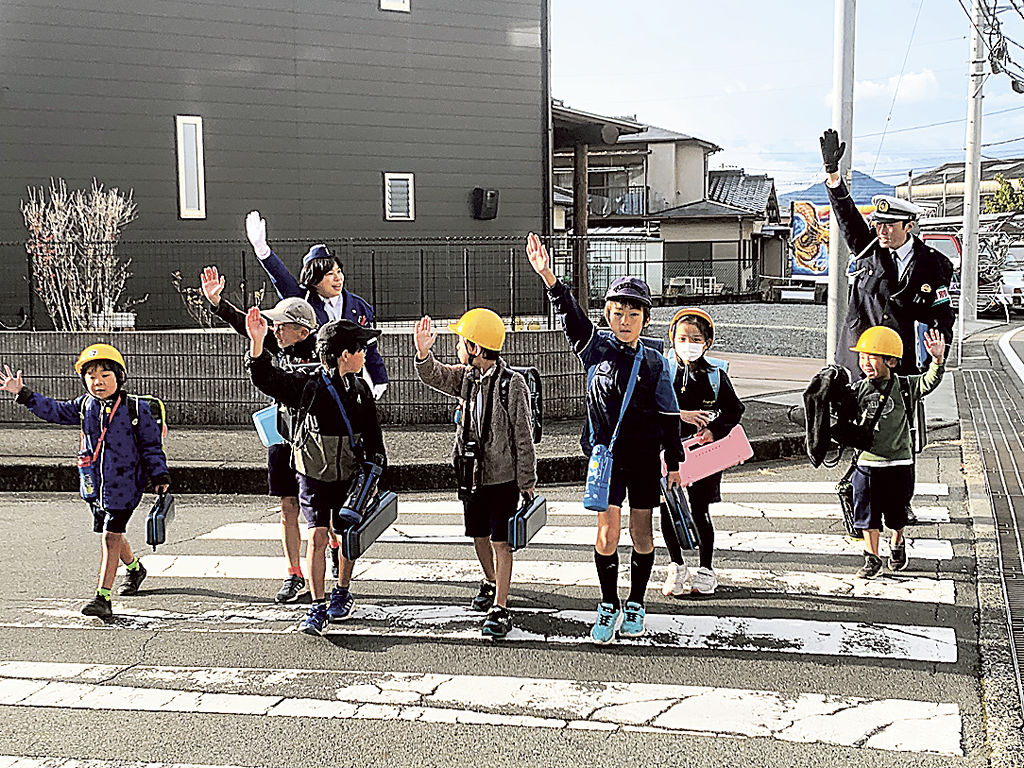 手を上げて横断歩道を渡る児童ら＝伊豆の国市内