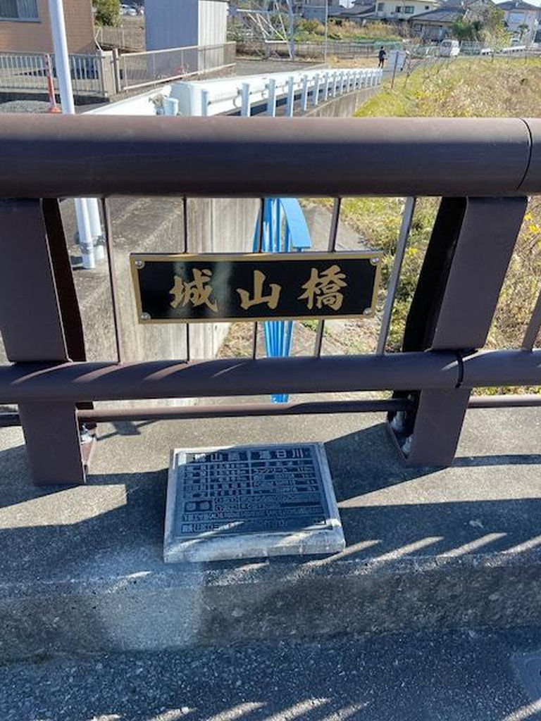 プラスチック製の板に、カッティングシートで作った文字を貼った新しい橋名板＝島田市船木の城山橋