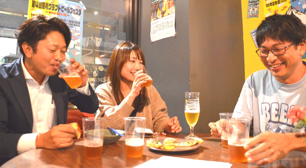 クラフトビール「大楽地米ビール」のベースを試飲する関係者ら＝掛川市内