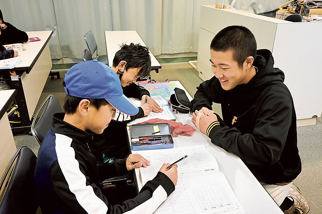 児童の宿題をサポートする部員（右）＝富士市の富士高