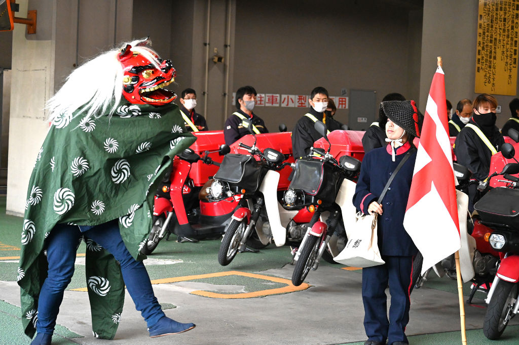出発式で披露された獅子舞（左）と明治期の制服を着た社員（右）＝静岡市葵区の静岡中央郵便局