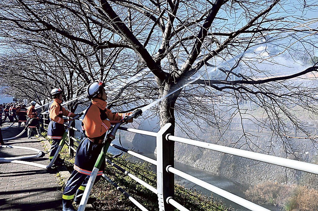 一斉放水する消防団員ら＝掛川市の掛川城公園三の丸広場付近