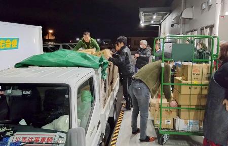 フードバンクが集めた炊き出し用の野菜などをトラックに積み込む、被災者支援団体「ＢＩＧ　ＵＰ石巻」のメンバーら＝５日午後、宮城県富谷市