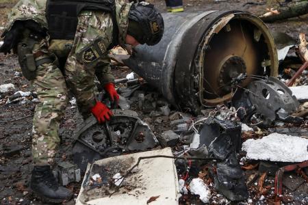 ロシア軍がウクライナ東部ハリコフに撃ち込んだミサイルの残骸を調べるウクライナ当局者＝２日（ロイター＝共同）