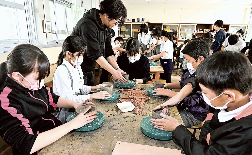 前田さん（左から３人目）の指導を受け、陶器づくりに挑戦する児童＝藤枝市立青島小