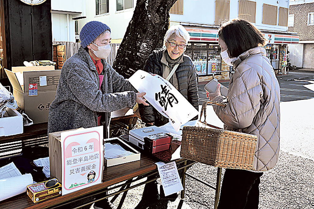 サバ料理を販売しながら義援金の趣旨を説明する増田さん（左）ら＝富士宮市中央町