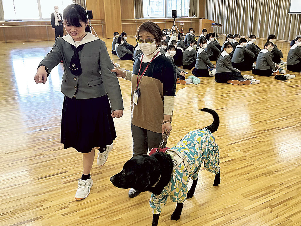 盲導犬を連れた落合さんの案内に挑戦する生徒＝静岡市葵区