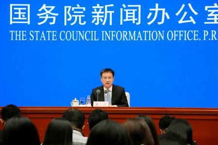 記者会見する中国国家統計局の康義局長＝１７日、北京（共同）