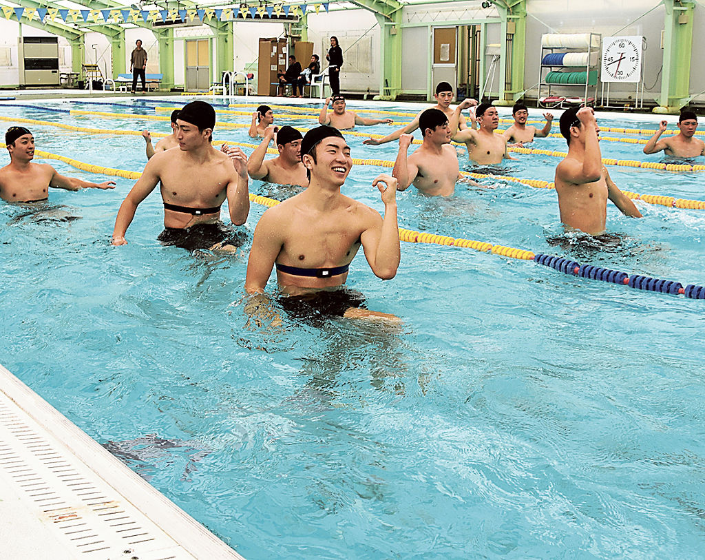 温泉が流れ込むプールで運動に取り組む男子学生ら＝松崎町のＢ＆Ｇ海洋センター