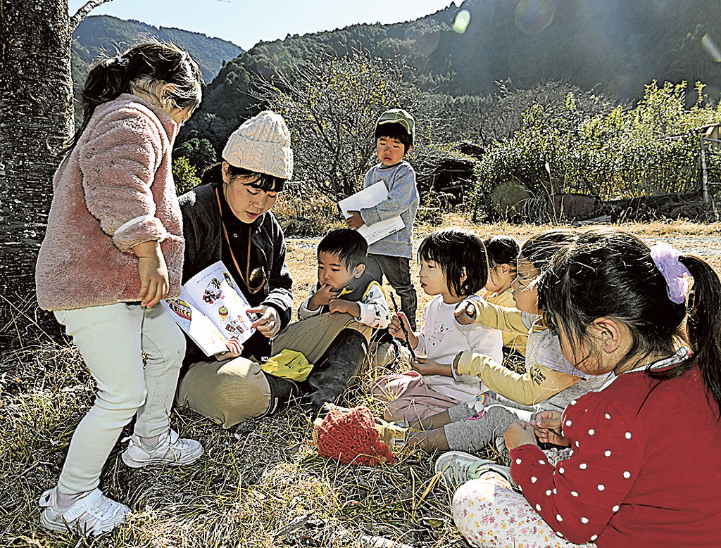 野外で絵本を楽しむ子どもたち＝静岡市葵区桂山