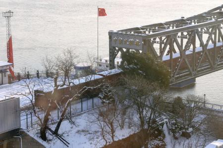 「中朝友誼橋」を渡って北朝鮮へ向かう貨物列車＝２０２２年１２月、中国遼寧省丹東（共同）