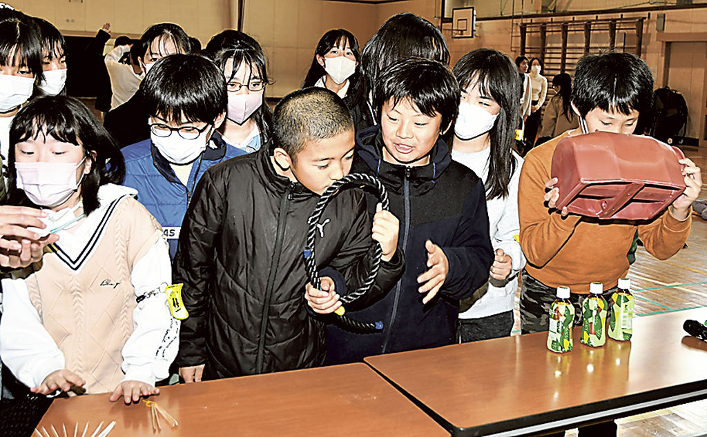 生分解性プラスチックで作られた漁具を手に取る児童＝富士宮市の大宮小