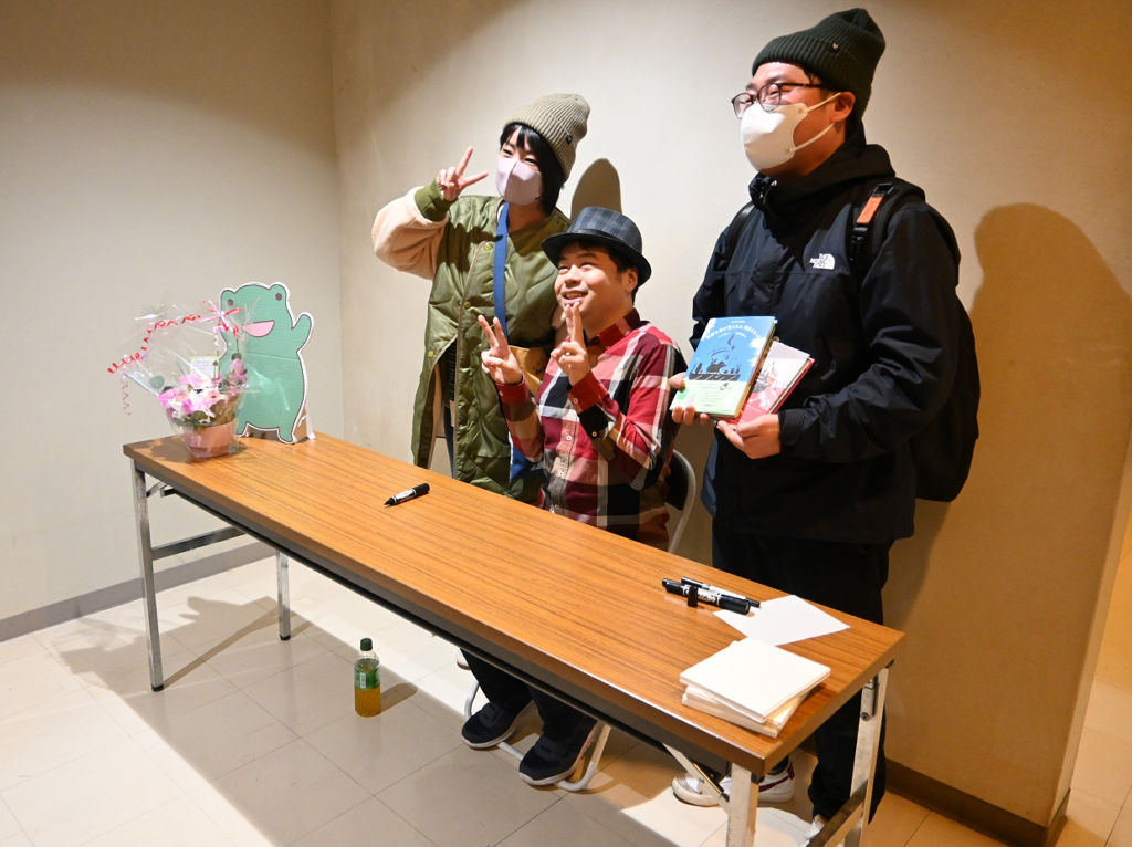 サイン会で来場者と記念写真に納まる葉っぱ切り絵作家のリトさん（中央）静岡市駿河区の駿府博物館