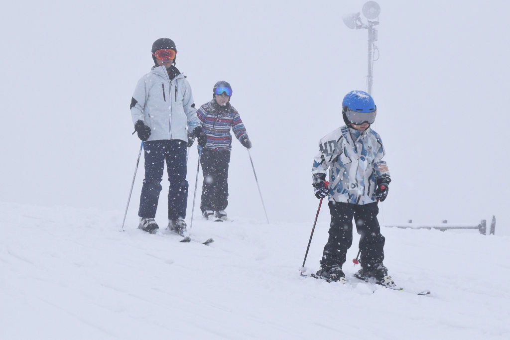 雪が降りしきる中でスキーを楽しむ親子連れ＝静岡市葵区のリバウェル井川スキー場