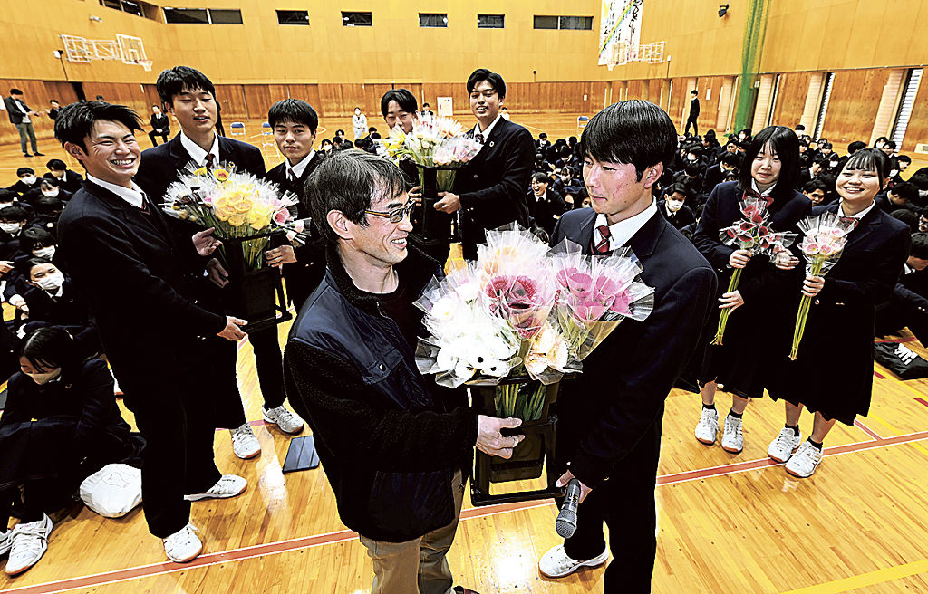 生徒にガーベラを手渡す山本さん（中央左）＝浜松市中央区の浜松開誠館高