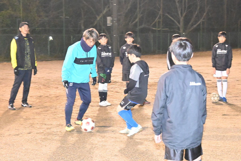 体験会でサッカーの指導を受ける生徒＝掛川市の城東中グラウンド