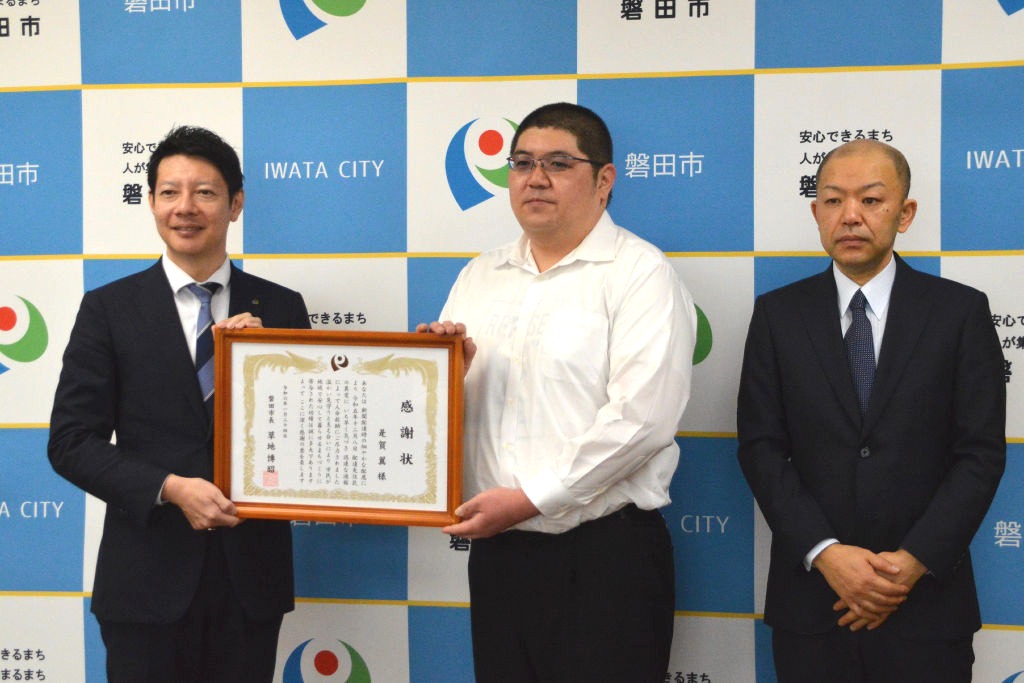 草地磐田市長（左）から感謝状を受け取った是賀さん（中央）＝市役所