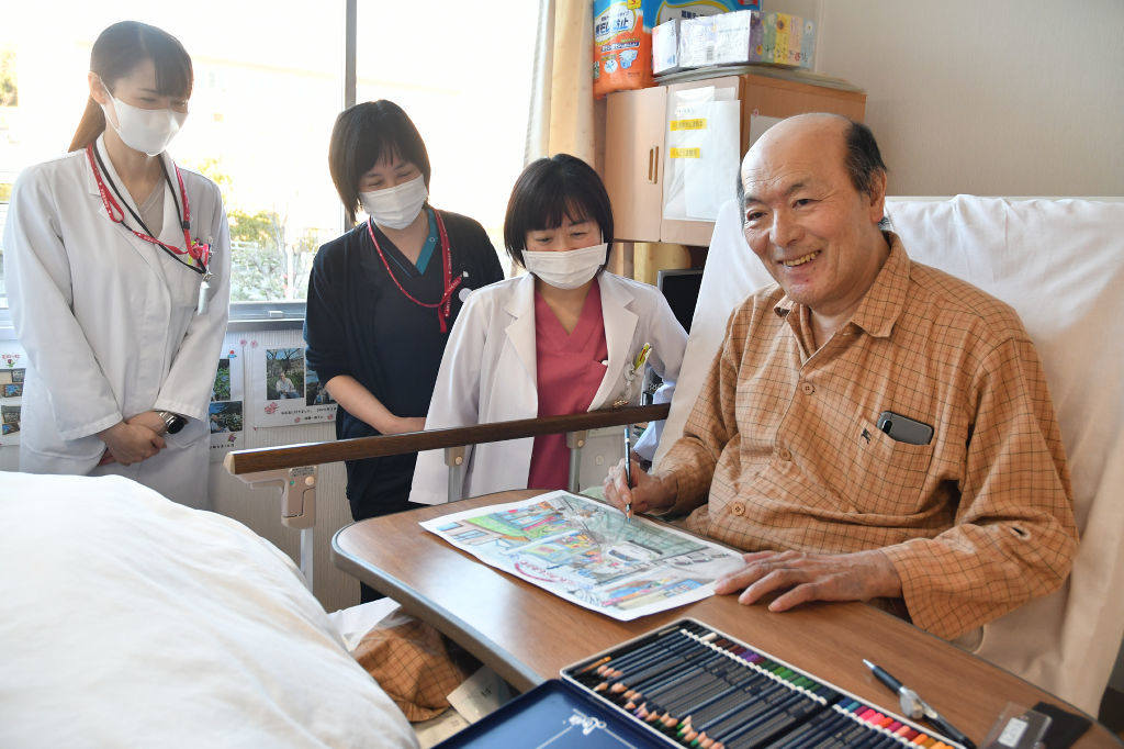病室で絵を描く後藤一成さん（右）＝２３日、富士市の共立蒲原総合病院
