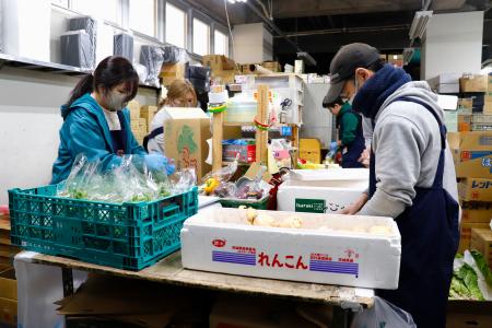 野菜の袋詰めや下処理をするスーパー「アキダイ」の従業員ら＝１月１７日、東京都練馬区