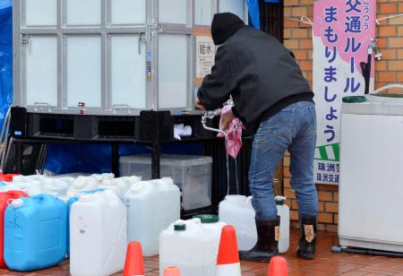 避難所でポリタンクに水をくむ避難者の男性＝１日午後、石川県珠洲市