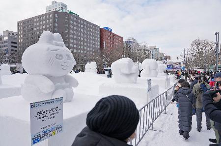 北海道の冬の風物詩「さっぽろ雪まつり」を楽しむ人たち＝４日午前、札幌・大通公園
