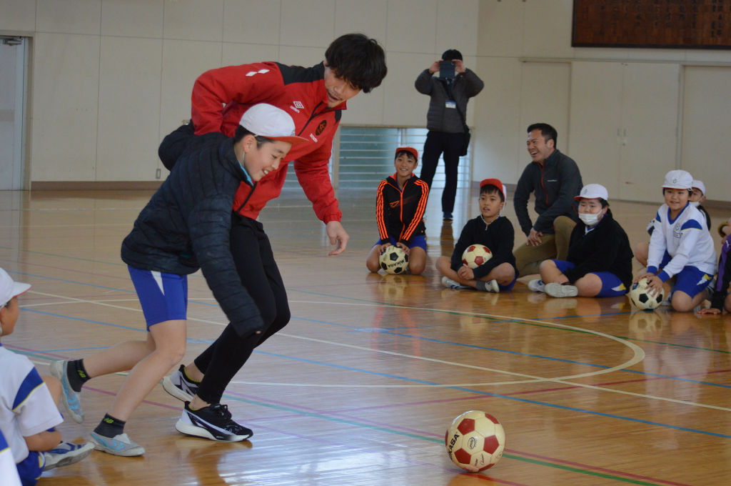 鈴木選手（右）とサッカーを楽しむ児童＝浜松市中央区の河輪小