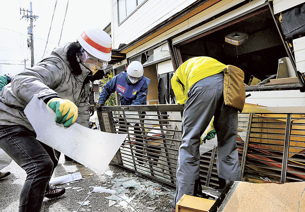 被災した家屋から運び出した災害ごみを分別するボランティア＝１０日午後、石川県輪島市