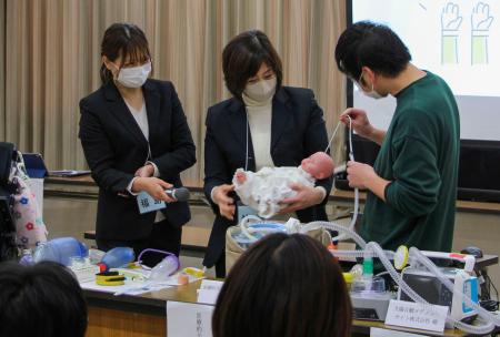 「医療的ケア児」を想定し、たんの吸引を模擬体験するイベント参加者ら＝１１日午後、大阪府茨木市