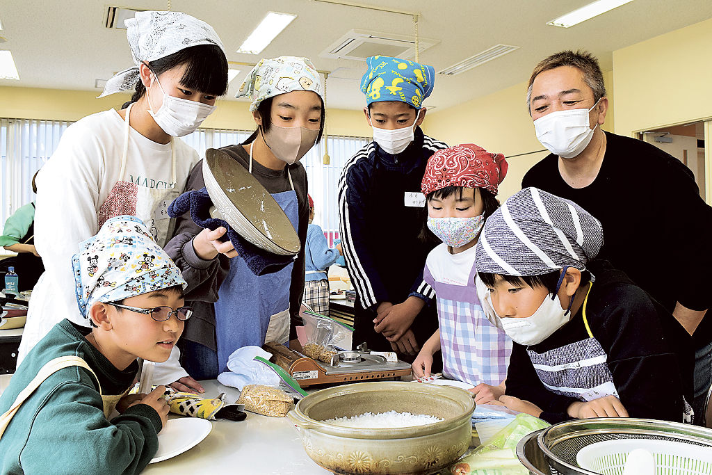 土鍋を開け、炊き上げたご飯を見つめる児童ら＝静岡市駿河区のＳＢＳ学苑静岡校（写真の一部を加工しています）