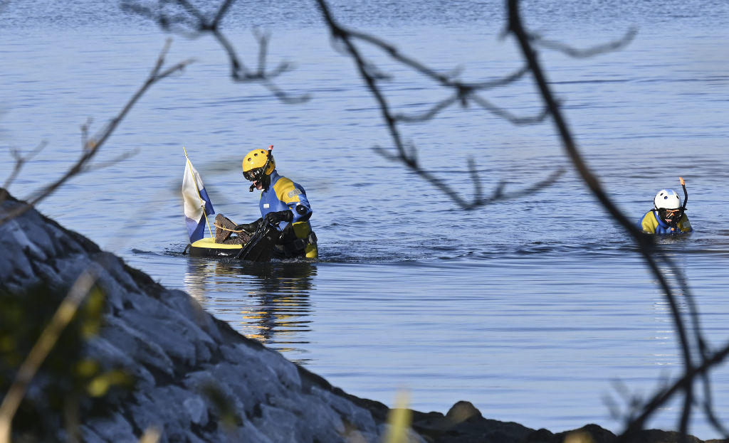 遺体の発見された現場付近の水中を調べる捜査員＝１３日午後４時ごろ、湖西市の浜名湖