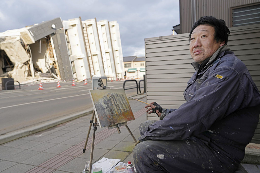 能登半島地震で倒壊した石川県輪島市のビルを描く鈴木誠さん＝３日
