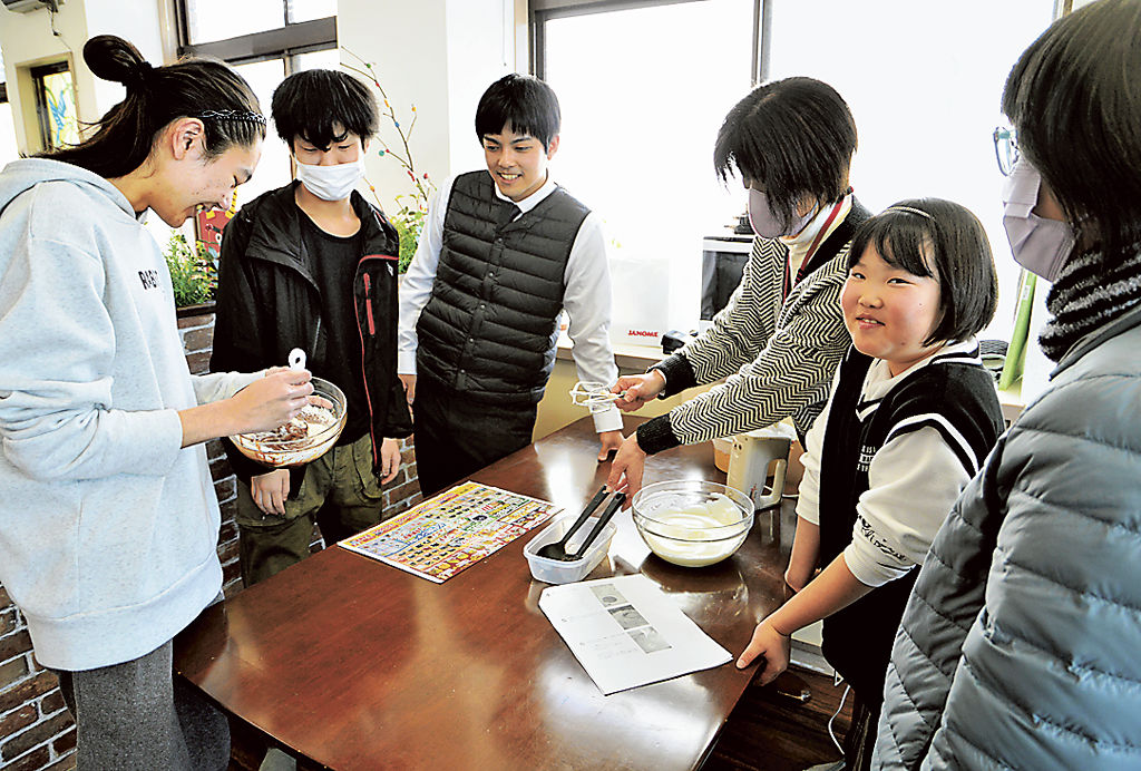 ケーキ作りに取り組む稲村翔太さん（左）。稲垣孝一さん（左から３人目）ら職員が子どもの活動をサポートする＝８日、富士市水戸島本町の適応支援教室「アルファー」