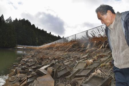 能登半島地震で壁面が崩れた農業用ため池を見つめる市保羊作さん＝７日、石川県珠洲市