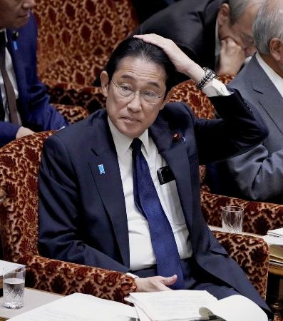 髪を触る岸田首相＝昨年１０月、国会