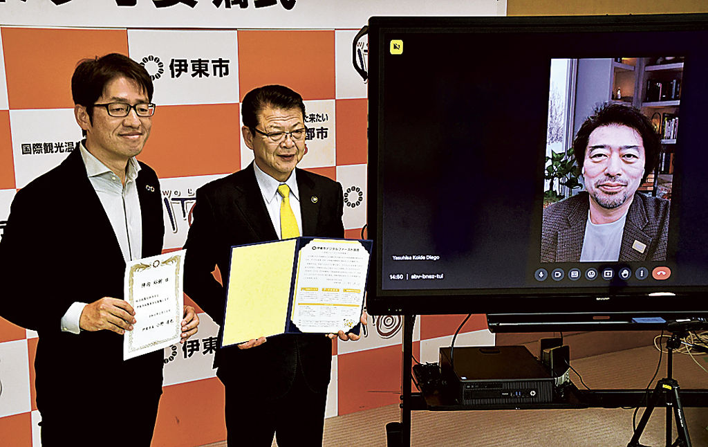 政策参与の委嘱を受けた陳内さん（左）と画面に映る小出さん（右）。中央は小野市長＝伊東市役所