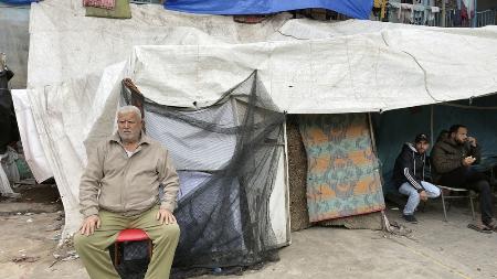 ＵＮＲＷＡ運営の学校敷地内にテントを張り、避難生活を送るハニ・サレハさん（左）＝１月２８日、パレスチナ自治区ガザ南部ラファ（ハッサン・エスドゥーディ撮影、共同）