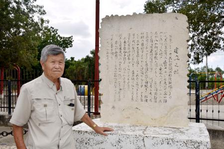 日本人移住者の歴史が記された石碑の前に立つ向井猛さん＝２０２３年８月、ドミニカ共和国ダハボン（共同）