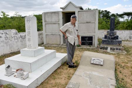 日本人入植者の墓地を歩く向井猛さん＝２０２３年８月、ドミニカ共和国ダハボン（共同）