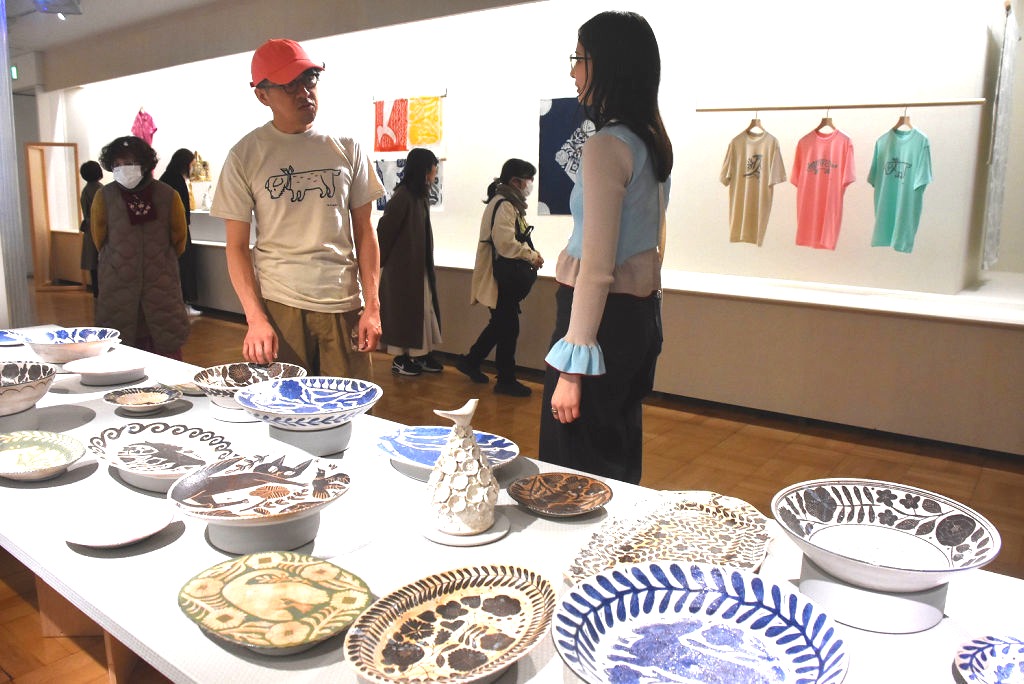 色とりどりの作品について説明する鹿児島さん（左）＝三島市の佐野美術館