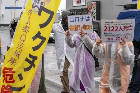 「ワクチンは猛毒」「コロナは存在しない」などの主張を掲げながら、茨城県つくば市内をデモする「神真都Ｑ会」のメンバー＝２０２４年１月