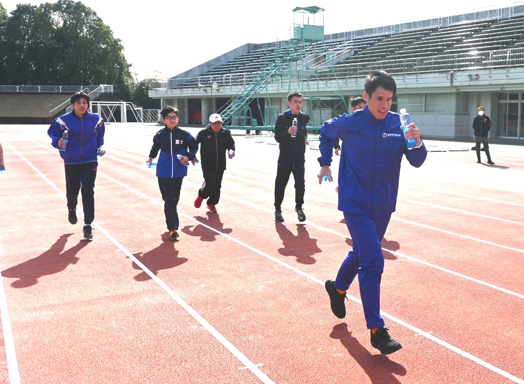 堀越さん（手前）の指導を受けて走る参加者ら＝富士市の富士総合運動公園