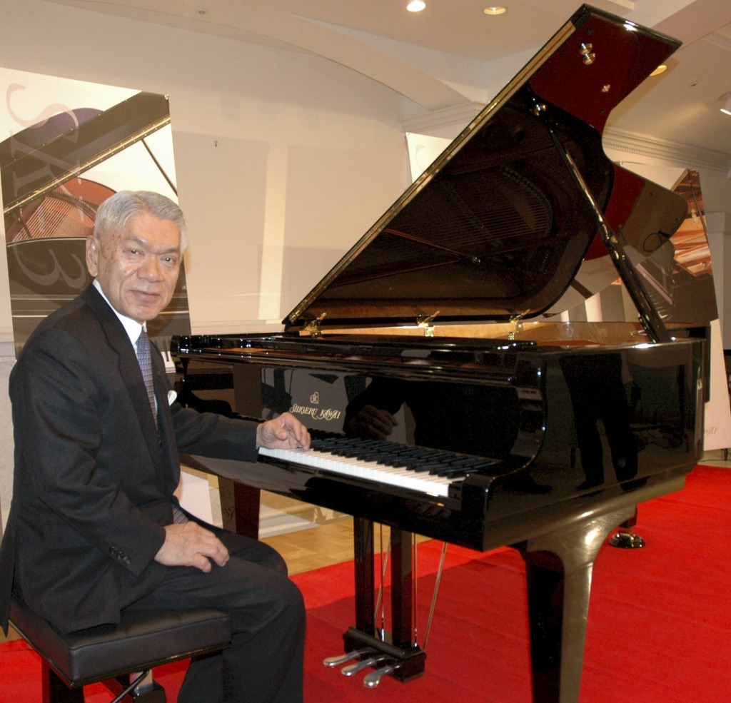 一新した河合楽器製作所の最高級グランドピアノ「シゲル・カワイ」を紹介する河合弘隆社長（当時）＝２０１２年１月、浜松市内
