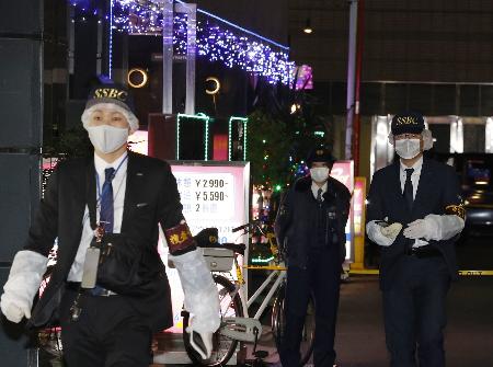 男性の遺体が見つかったホテルを出る警視庁の捜査員＝２０２２年１月、東京・池袋